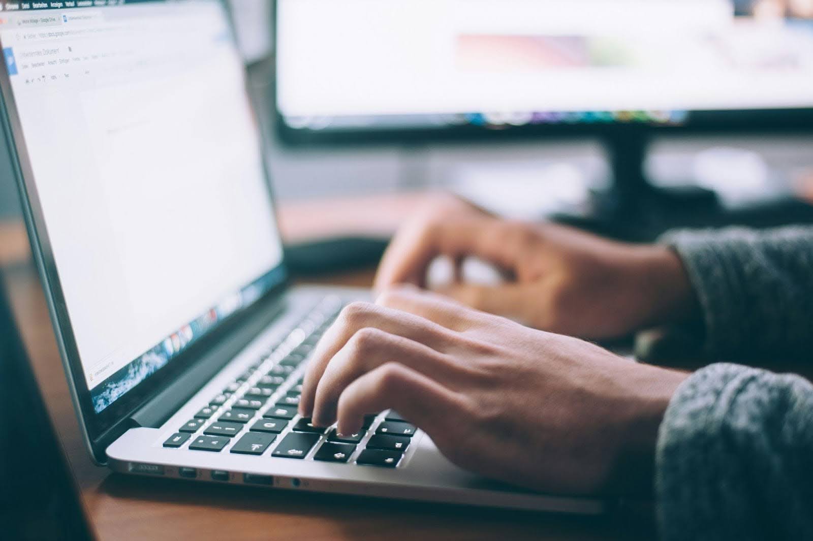 A man is typing on his laptop