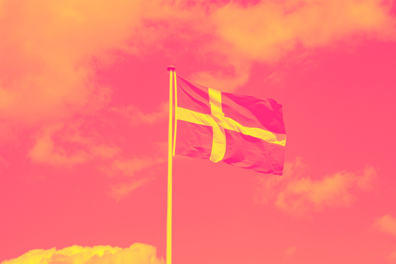 Denmark flag waving in the wind with sky and clouds