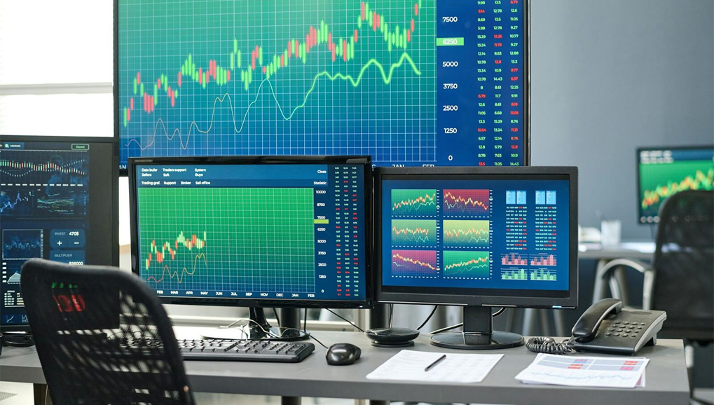 Computer screens inside an office that show graphs